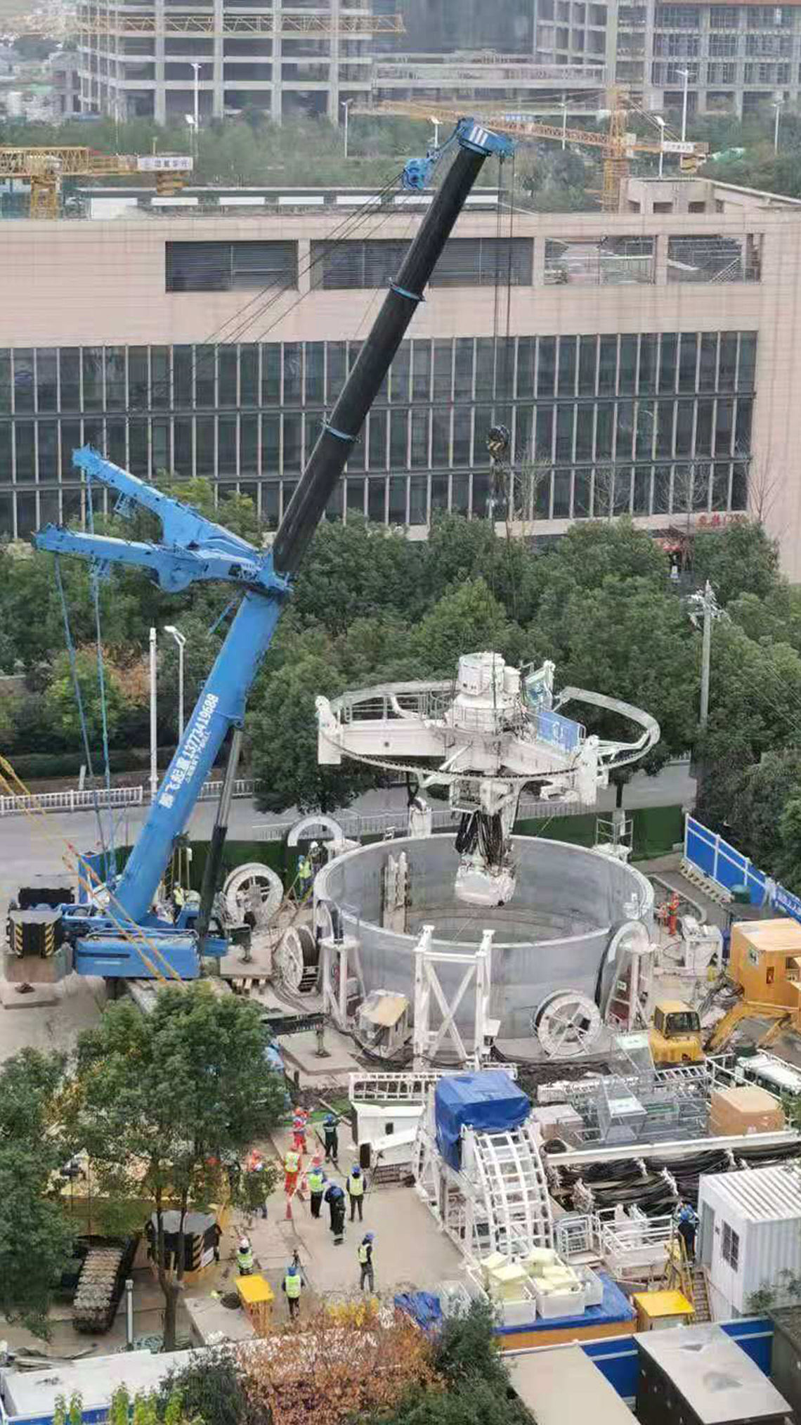 蓝色起重机将停车场系统吊入竖井的画面。